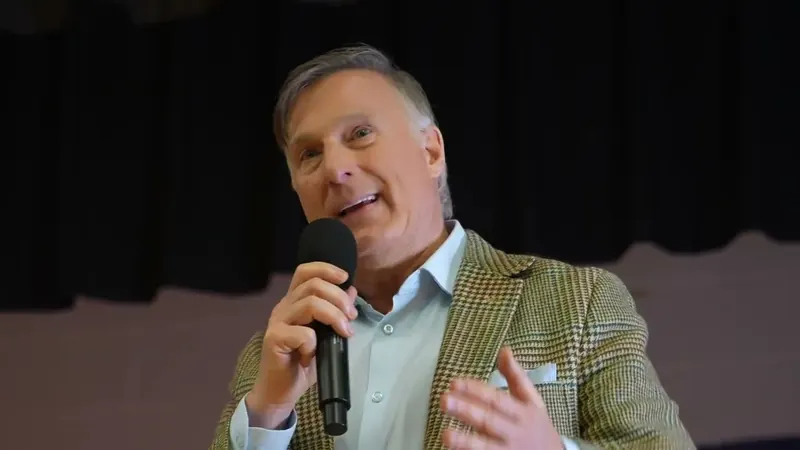 Maxime Bernier speaking into a microphone at the town hall